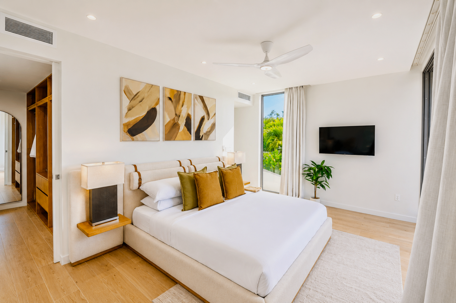 Side view of the bedroom with abstract art, mounted television, and warm wood accents