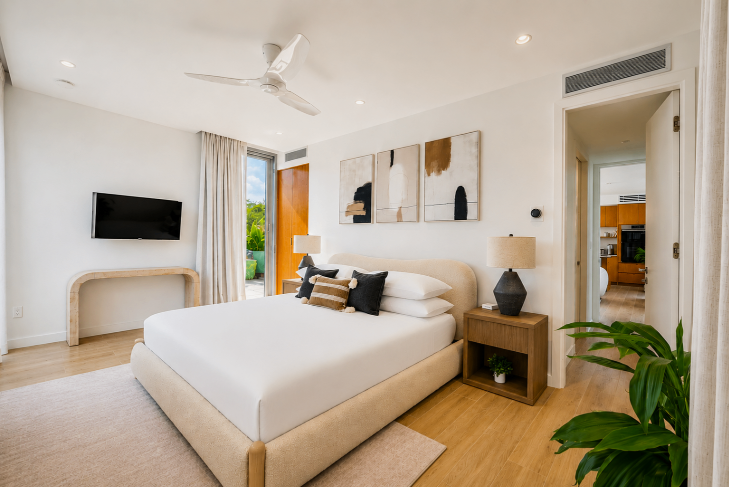 Second bedroom with soft natural light, wood nightstands, and ensuite access