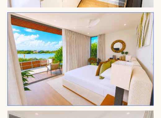 Master bedroom with open sliding doors framing a lake and water view