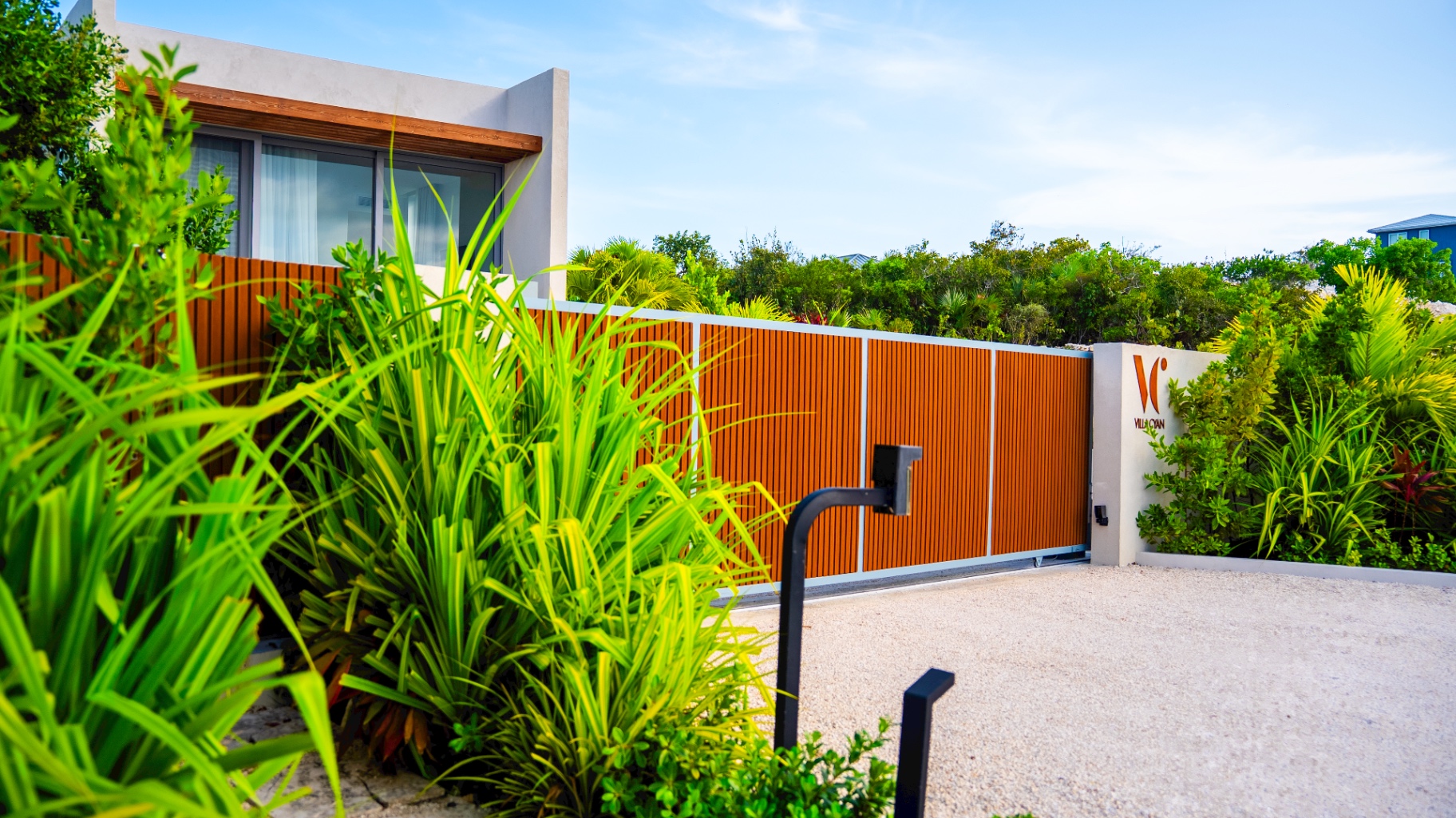 Private gated entrance to Villa Cyan surrounded by tropical landscaping